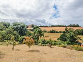 A view of trees and a field with ruins at Kingfisher Cottage in East Ayton