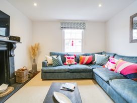 A living room with a sectional sofa and a TV at Church Hill House in Port Isaac