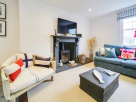 A living room with a fireplace and seating area at Church Hill House in Port Isaac