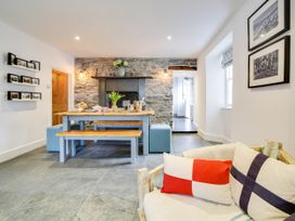 A dining room with a table and bench at Church Hill House in Port Isaac