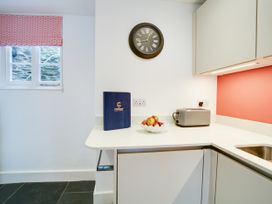 A kitchen with a clock and a fruit bowl at Church Hill House in Port Isaac