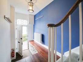 A hallway with a bench and a staircase at Church Hill House in Port Isaac
