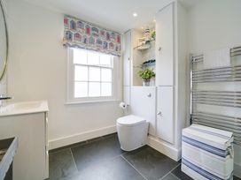 A bathroom with a toilet, sink, and towel rail at Church Hill House in Port Isaac