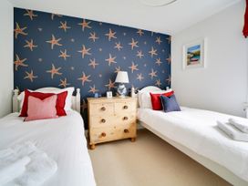 A bedroom with two beds and a chest of drawers at Church Hill House in Port Isaac