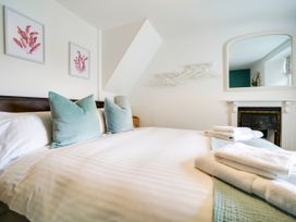 A bedroom with a bed and decorative pillows at Church Hill House in Port Isaac