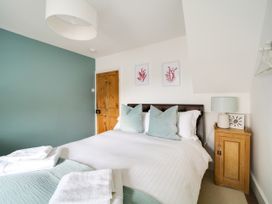 A bedroom with a bed and wall art at Church Hill House in Port Isaac