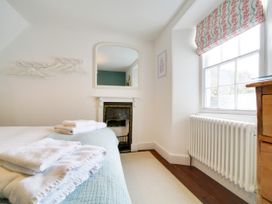 A bedroom with a bed and a mirror at Church Hill House Port Isaac