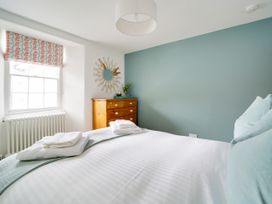 A bedroom with a bed and dresser at Church Hill House in Port Isaac