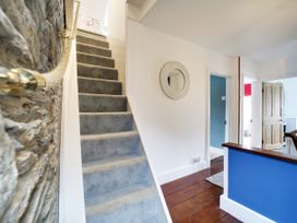 A staircase with a handrail in the hallway at Church Hill House in Port Isaac