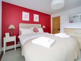 A bedroom with a bed, bedside table and drawer at Church Hill House in Port Isaac