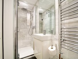 A bathroom with a shower, sink, and towel rail at Church Hill House in Port Isaac