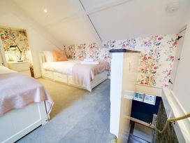 A bedroom with two beds and a staircase at Church Hill House in Port Isaac