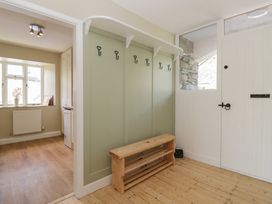 A hallway with coat hooks and a bench at The Barn at Grasmere