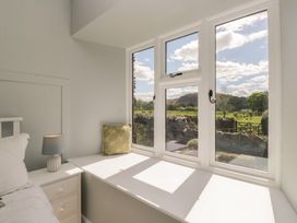 A bedroom with a window and lamp at The Barn at Grasmere in Grasmere