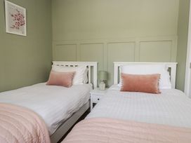 A bedroom with two beds and a lamp at The Barn at Grasmere