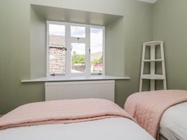 A bedroom with beds and a window at The Barn at Grasmere