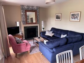 A living room with a blue sofa and a pink armchair at The Barn at Grasmere in Grasmere