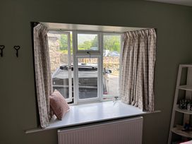 A window with curtains and a pillow on the sill at The Barn at Grasmere in Grasmere