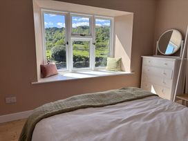 A bedroom with a window seat and dresser at The Barn at Grasmere