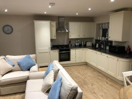 A kitchen with cabinets, a stove, and a sofa at Pen Y Ffrith Lodge in Prestatyn