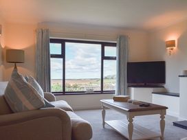 A living room with a sofa and television at Cae Coch in Brynteg near Benllech