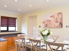 A dining room with a table set for meals at Cae Coch Brynteg near Benllech