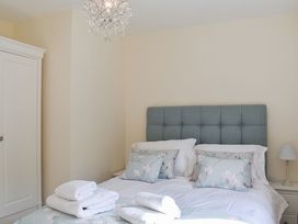A bedroom with a bed and wardrobe at Cae Coch in Brynteg near Benllech