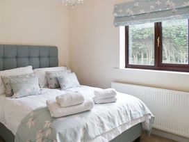 A bedroom with a bed and window at Cae Coch in Brynteg near Benllech