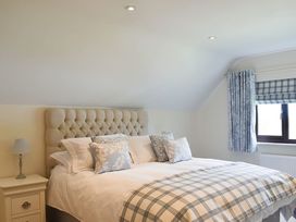 A bedroom with a bed and bedside lamp at Cae Coch in Brynteg near Benllech