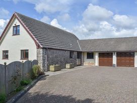 A house with a driveway and garage at Cae Coch in Brynteg near Benllech