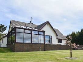 A house with a conservatory and garden at Cae Coch in Brynteg near Benllech
