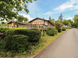 A lodge with decking and hedges along a road at 28 Troutbeck in Bassenthwaite