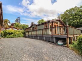 An outdoor view of a house with a deck and gravel driveway at 28 Troutbeck in Bassenthwaite
