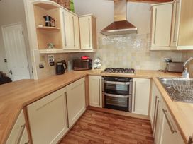 A kitchen with a cooktop, oven, and microwave at 28 Troutbeck in Bassenthwaite