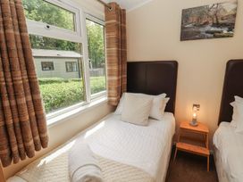 A bedroom with two single beds and a window at 28 Troutbeck in Bassenthwaite