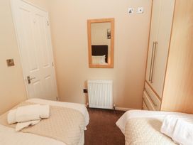 A bedroom with two beds and a mirror at 28 Troutbeck in Bassenthwaite