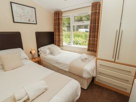 A bedroom with two beds and a wardrobe at 28 Troutbeck in Bassenthwaite