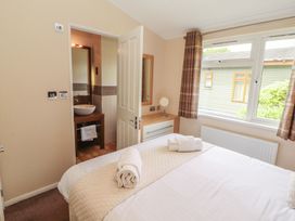 A bedroom with a bed and adjacent bathroom at 28 Troutbeck in Bassenthwaite