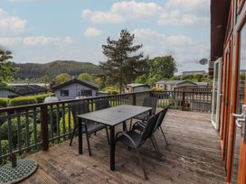 An outdoor patio with a table and chairs overlooking hills at 28 Troutbeck in Bassenthwaite