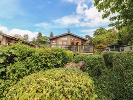 A house with a deck surrounded by greenery at 28 Troutbeck in Bassenthwaite