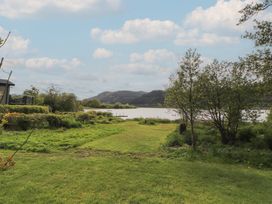 A view of a lake surrounded by grass and trees at 28 Troutbeck in Bassenthwaite