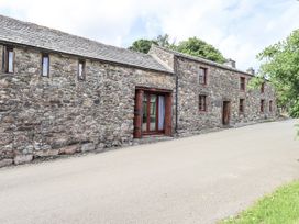 An exterior view of a stone house with a road at Chapel Cottage Ennerdale near Cleator Moor
