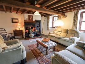 A living room with a sofa and fireplace at Chapel Cottage in Ennerdale near Cleator Moor