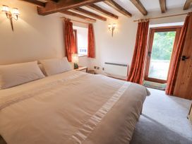 A bedroom with a bed and curtains at Chapel Cottage, Ennerdale near Cleator Moor