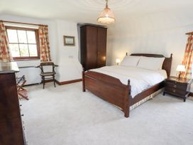 A bedroom with a bed, nightstand, and wardrobe at Chapel Cottage Ennerdale near Cleator Moor