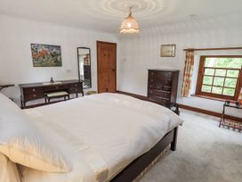 A bedroom with a bed and dresser at Chapel Cottage in Ennerdale near Cleator Moor