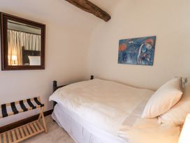 A bedroom with a bed and mirror at Chapel Cottage in Ennerdale near Cleator Moor