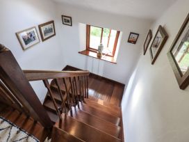 A stairway with a window and photographs at Chapel Cottage in Ennerdale near Cleator Moor