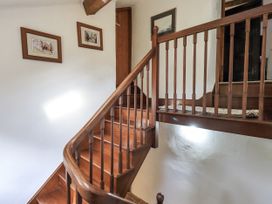 A staircase with wooden handrail and paintings at Chapel Cottage Ennerdale near Cleator Moor