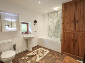 A bathroom with a bathtub, toilet, and washbasin at Chapel Cottage in Ennerdale near Cleator Moor